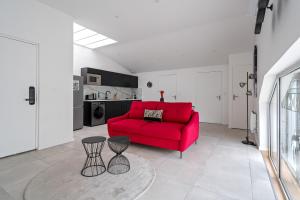 een woonkamer met een rode bank en een tafel bij Loft ROSALIE - Le Méridien #Parking #Lave-linge #Clim #Netflix in Charbonnières-les-Bains