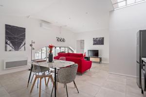 een woonkamer met een rode bank en een tafel bij Loft ROSALIE - Le Méridien #Parking #Lave-linge #Clim #Netflix in Charbonnières-les-Bains +47 foto's