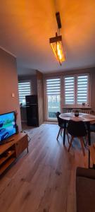 a living room with a dining table and a television at Apartament Retro in Wałbrzych