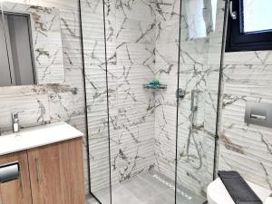 une salle de bain avec douche et lavabo dans l'établissement Agnanti-apartments, à Nikiti 30 autres photos