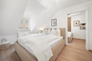 a white bedroom with a large bed with white sheets at Malu Rooms - im Stadtzentrum, SmartTV, Netflix, 24h Checkin in Ludwigsburg +17 photos