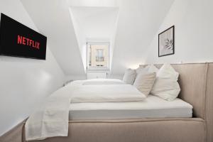 a bed with white sheets and pillows in a room at Malu Rooms - im Stadtzentrum, SmartTV, Netflix, 24h Checkin in Ludwigsburg