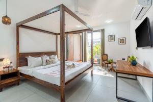 a bedroom with a canopy bed and a television at Alaya Stays Ramalaya 8 BHK Villa with Garden in Jaipur