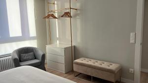 a bedroom with a bed and a chair and a lamp at CHAPITELES Catedral in Burgos