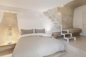 a bedroom with a white bed and a staircase at La Dimora Di Metello in Matera