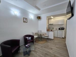 a living room with a table and chairs and a kitchen at La Casina in Follonica