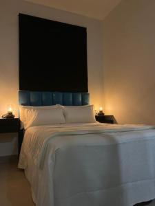 カマスにあるBeautiful Rooms Nº2のベッドルーム1室(大型ベッド1台、青いヘッドボード付)