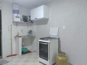 a kitchen with a stove top oven in a room at kitnet 01 preço popular in Brasília