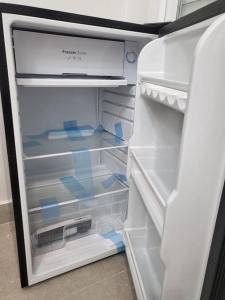 an empty refrigerator with its door open and its door at Beautiful Rooms Nº3 in Camas