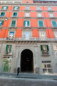 Un uomo che cammina davanti a un palazzo di Ciao Home a Napoli