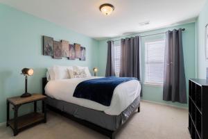 a bedroom with a bed with blue walls and a window at Spacious Family Friendly Townhome in Central Park in Denver