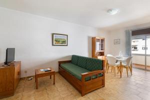 un salon avec un canapé vert et une table dans l'établissement Paula Bela by Garvetur, à Quarteira