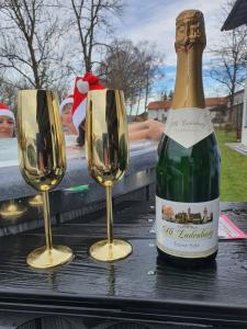 a bottle of wine and two glasses on a table at Casa Bianka in Fridolfing