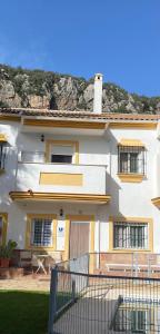 a white building with a fence in front of it at Casa Rural las Rosas de Benaojan in Benaoján