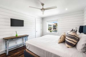 a bedroom with a bed and a flat screen tv at The Good Life in Inlet Beach