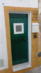 a green door on the side of a building at Casa dos Josés in Elvas +5 photos
