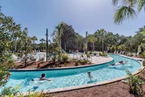 a group of people in a swimming pool at a resort at Southern Charm in Santa Rosa Beach