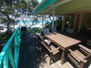 a wooden deck with a table and chairs on a house at The Green Gate in Zinkwazi Beach