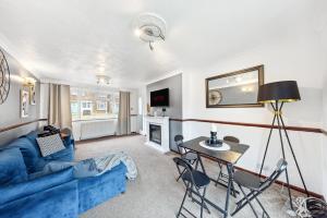 グレーブゼンドにあるLarge 3 Bed Home With Double Driveway & Gardenの青いソファとテーブルのあるリビングルーム