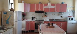a kitchen with red cabinets and a table and a refrigerator at Casa Alice, in collina con panorama in Lonato +13 photos