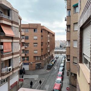 a city street with parked cars and buildings at Habitación en centro de Alicante in Alicante