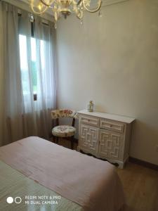 ein Schlafzimmer mit einem Bett, einer Kommode und einem Stuhl in der Unterkunft VILLA Mamuki - habitación doble in Prezanes