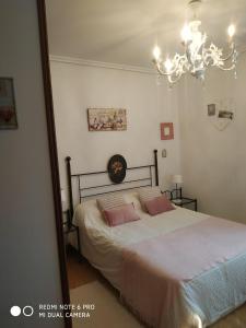 Schlafzimmer mit einem Bett mit rosa Kissen und einem Spiegel in der Unterkunft VILLA Mamuki - habitación doble in Prezanes