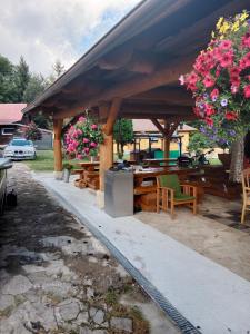 a wooden pavilion with tables and chairs and flowers at Penzion Monty Ranch in Štôla