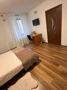 a bedroom with a bed and a desk and a door at Madalina's House in Braşov