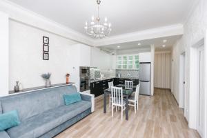 a living room with a blue couch and a kitchen at SkyHouse-High Comfort Gem in Central Downtown in Chişinău