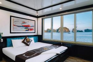 Un dormitorio con dos camas en un barco con ventanas. en ADUTA CRUISE, en Cat Ba