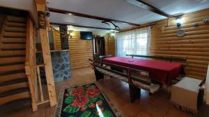 a dining room with a red table in a cabin at Cabana Dochita 2 in Ceahlău