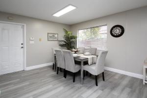 a dining room with a table and chairs and a clock at Entire Magill House by RiverPark in Fresno