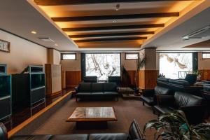 a living room with couches and a tv at Yuyado DAIICHI in Naka-shibetsu