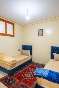a room with two beds and a rug at Bab Atas appartment N4 in Ourika Valley in Marrakech