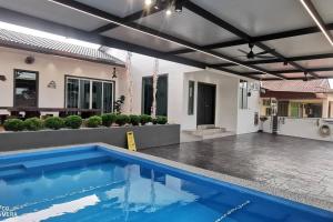 a swimming pool in front of a house at Kulim Mini HomeStay in Kulim