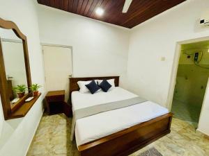 una camera da letto con un letto e uno specchio di The Beez a Negombo