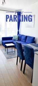 salon z niebieską kanapą, stołem i krzesłami w obiekcie Fairytales Apartment we Wrocławiu