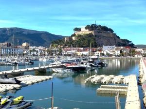 a bunch of boats docked in a marina with a castle at Denia Apartment Rental - Vivir La Vida in Denia