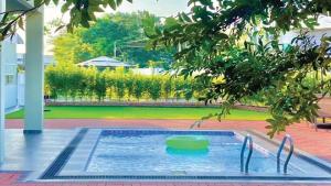 ein Schwimmbad mit einem grünen Objekt im Wasser in der Unterkunft LAMAN KASEH Homestay Bukit Katil 4bedroom with Swimming Pool in Ayer Keroh