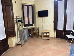a living room with a tv on the wall at B&B L’Angolo sulla Piazza in Mirabella Imbaccari