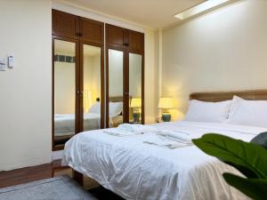 Klong ToiApamet Hotel Sukhumvit 55的卧室里有一张带镜子的白色大床