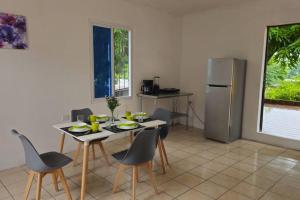 a kitchen with a table and chairs and a refrigerator at Apartamentos Pradera's C in Escuintla