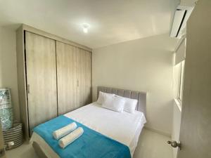 a small bedroom with a bed with two towels on it at Vista panoramica al Mar y Piscina in Cartagena de Indias +14 photos