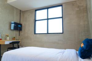 a bedroom with a white bed and a window at Behomy Crown Tangerang in Tangerang