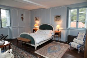 a bedroom with a bed and a chair at Manoir de Belle-Noë in Dol-de-Bretagne