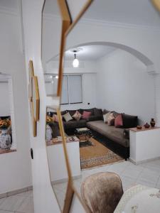 a living room with a couch and a mirror at Quiet and family apartment, appartement in Marrakech