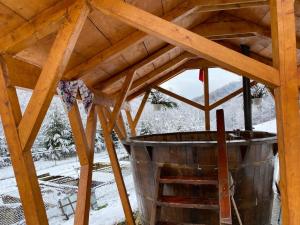a wooden structure with a large bucket in a roof at Cabana Mădălin in Gurani