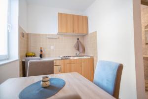 a kitchen with a table with a blue hat on it at Apartmani Biser Kupresa 2 in Kupres