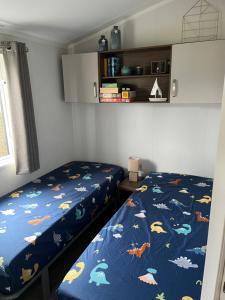 ein Schlafzimmer mit zwei Betten und einer blauen Bettdecke in der Unterkunft Chalet-Frank in Lathum